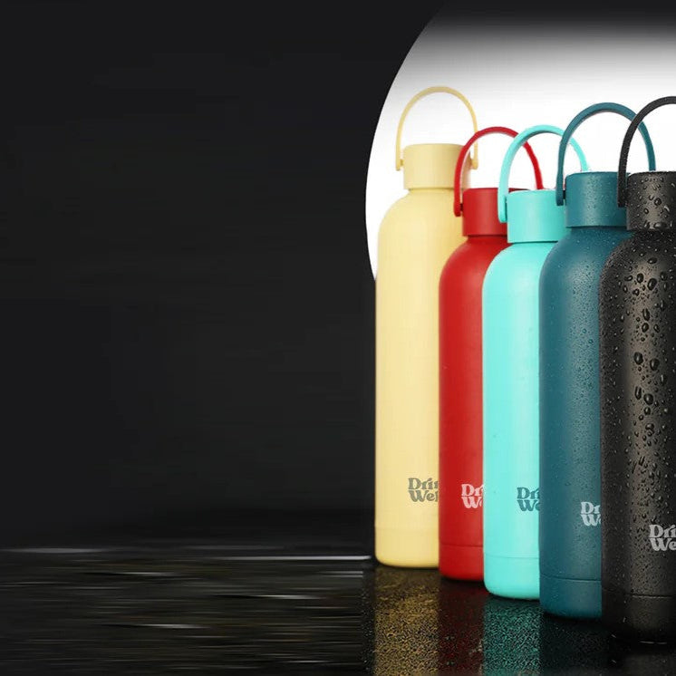 Collection de bouteilles réutilisables DrinkWell® aux couleurs variées, illustrant l’engagement écologique de la marque pour réduire les déchets plastiques.